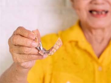 person holding dentures